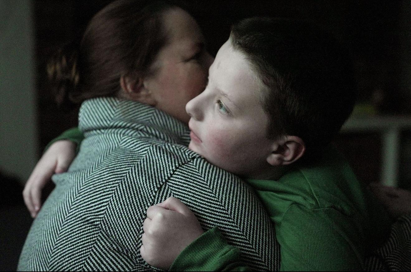 A child embracing a caregiver