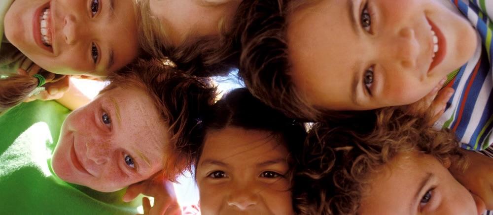 A diverse group of children smiling together in a circle