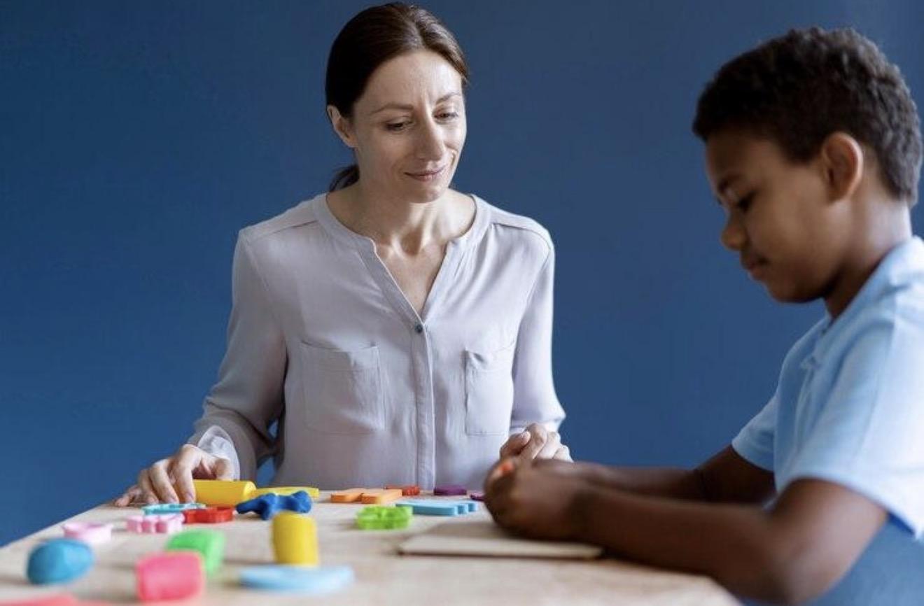 A child and support professional completing a hands-on learning activity together