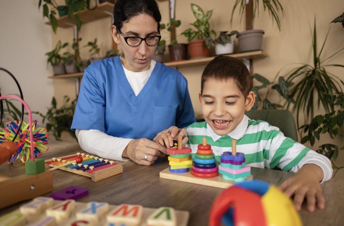 A child participating in a guided learning activity with a support professional